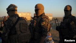 Fighters of Syrian Democratic Forces (SDF) stand together near the village of Baghouz, Deir Al Zor province, Syria March 1, 2019. 
