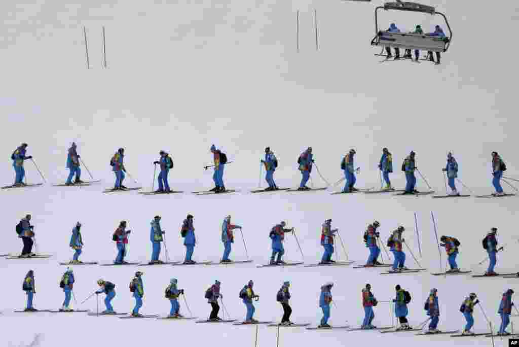 Workers groom the women's downhill course at the Rosa Khutor Alpine center at the 2014 Winter Olympics, Feb. 14, 2014.