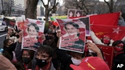 Warga Myanmar yang tinggal di Jepang dan pendukungnya memegang foto pemimpin Myanmar Aung San Suu Kyi saat melakukan protes di depan Kementerian Luar Negeri di Tokyo, Rabu, 3 Februari 2021. (Foto: AP)