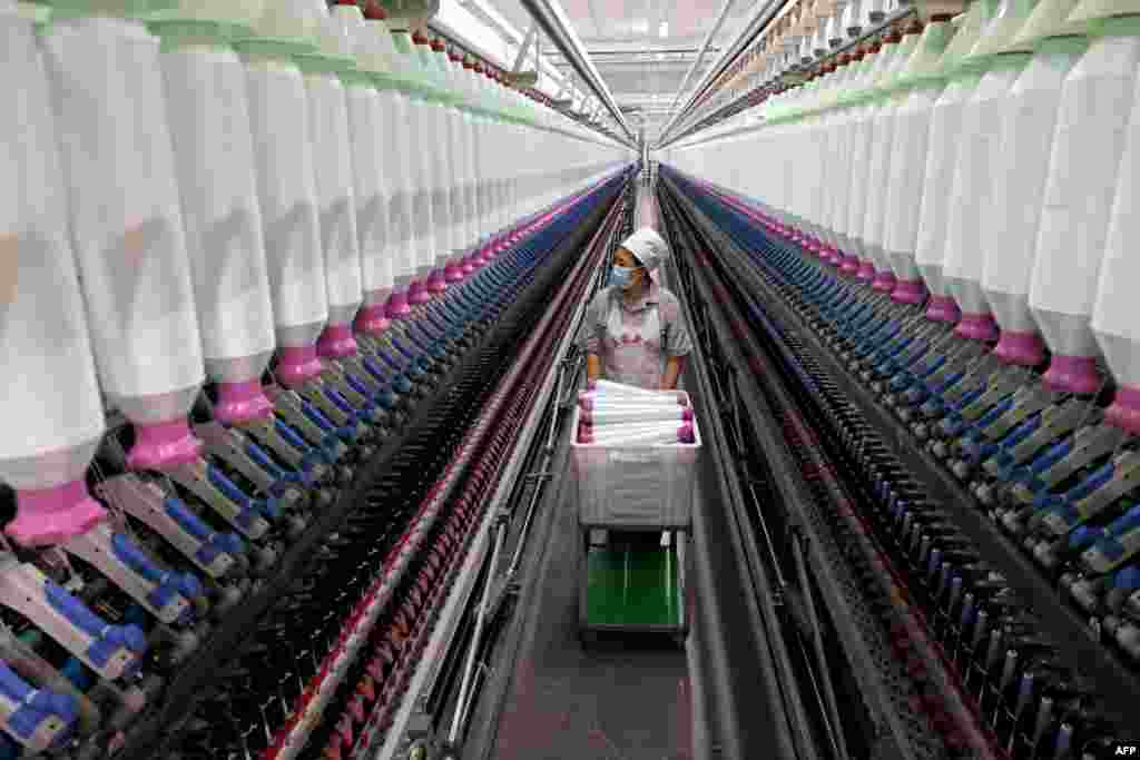 A worker checks on a production line of high-end threads in a factory in Zaozhuang, eastern China's Shandong province, Dec. 15, 2024. 