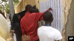 Voters look for their names before casting their ballots during elections in N'Djamena, Chad, Sunday, April 10, 2016.