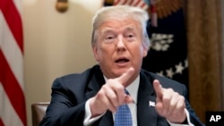 FILE - President Donald Trump points to members of the media as he speaks during a meeting in the Cabinet Room of the White House in Washington, Aug. 1, 2018.