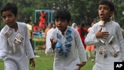 FILE - Children wear strings of cigarette and chewable tobacco and rehearse for a play on World No Tobacco Day in Gauhati, India.