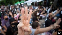 Pro-democracy activists flash three-fingered salutes outside a prison in which some of the activists are kept in Bangkok, Thailand, Oct. 23, 2020.