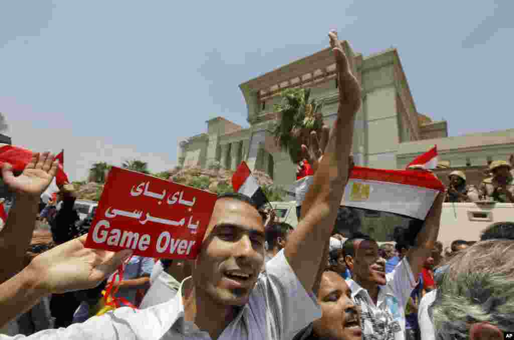 Egyptians celebrate after Egypt&#39;s chief justice Adly Mansour is sworn in as the nation&#39;s interim president, July 4, 2013. Arabic reads, &quot; bye bye Morsi.&quot; 