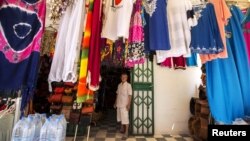 FILE - Tunisian shopkeeper Aghmi Bubaker speaks with Reuters journalists at his shop in Sousse, Tunisia, June 30, 2015. 