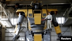 Sakakibara Kikai's engineer Go Sakakibara poses with the bipedal robot Mononofu during its demonstration at its factory in Shinto Village, Gunma Prefecture, Japan, April 12, 2018. (REUTERS/Kim Kyung-Hoon)