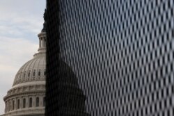 The U.S. Capitol dome is seen behind a security fence in Washington, Jan. 11, 2021.