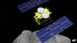 FILE - This computer graphics image released by the Japan Aerospace Exploration Agency (JAXA) shows the Hayabusa2 spacecraft above the asteroid Ryugu.