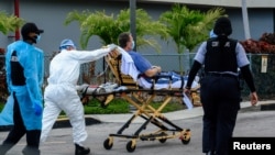 Emergency Medical Technicians (EMT) arrive with a correctional patient at North Shore Medical Center where the coronavirus disease (COVID-19) patients are treated, in Miami, Florida, July 14, 2020.