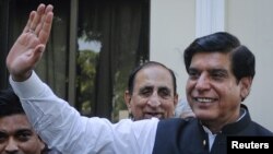 Pakistan's new Prime Minister Raja Pervez Ashraf waves to the media in Islamabad, Pakistan, June 22, 2012. 