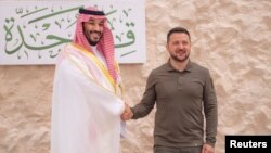 Putra Mahkota Saudi Mohammed bin Salman berjabat tangan dengan tamunya, Presiden Ukraina Volodymyr Zelenskyy, yang ikut menghadiri KTT Liga Arab di Jeddah, Jumat (19/5). 