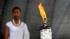 A girl stands in the background after escorting the Rwandan genocide flame, known as the 'Kwibuka' (Remembering) 20-years, at the Kicukiro Grounds as the country prepares to commemorate the 1994 Genocide in the Rwandan capital, April 5, 2014.