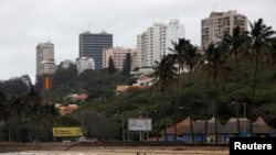 Fishermen cast their nets beneath the skyline of Mozambique's capital Maputo in this file picture taken Nov. 2009. 