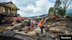 Warga berjalan di kawasan terdampak hujan lebat yang membawa banjir bandang dan tanah longsor saat mereka mengungsi di Agam, provinsi Sumatera Barat, 12 Mei 2024. (Antara Foto/Iggo El Fitra/via REUTERS)