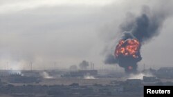 An explosion is seen over the Syrian town of Ras al-Ain, as seen from the Turkish border town of Ceylanpinar, Sanliurfa province, Turkey, Oct. 12, 2019.
