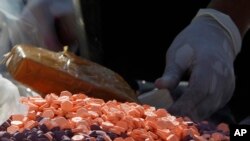 FILE PHOTO - A Cambodian drug expert prepares drug pills during a ceremony to mark the International Day Against Drug Abuse and Illicit Trafficking, in Phnom Penh, Cambodia, Tuesday, June 26, 2018. 