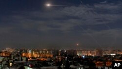 In this photo released by the Syrian official news agency SANA, shows missiles flying into the sky near international airport, in Damascus, Syria, Jan. 21, 2019