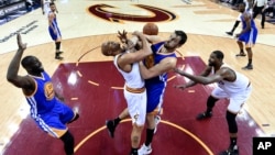 L’avant des Cavaliers du Cleveland, Richard Jefferson, au centre gauche, et le centre de Warriors du Golden State, Andrew Bogut, se disputent une balle au cours de la seconde mi-temps du match 4 de la finale NBA de basket-ball joué à Cleveland, vendredi 10 juin 2016. (Bob Donnan / Pool Photo via AP)
