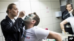 Yulia, wife of Russian opposition leader Alexei Navalny treats him after unknown attackers doused him with green antiseptic outside a conference venue in Moscow, Russia, April 27, 2017. 