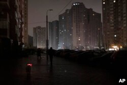 A dog with a lit up collar walks in a street during a blackout in Kyiv, Ukraine, Nov. 16, 2022.