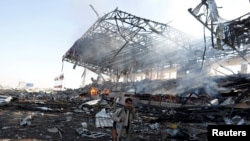 A Houthi fighter talks on the phone as he walks at the site of an air strike on a parade square in Sana'a, Yemen, Nov. 5, 2017. 