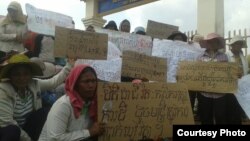 រូបឯកសារ៖ បាតុករ​ជា​អ្នក​ភូមិ​ដែល​កំពុង​ស្វែង​រក​ដំណោះ​ស្រាយ​ក្នុង​ជម្លោះ​ដី​ធ្លី កាន់​បដា​តវ៉ា​អំឡុង​ពេល​មក​ដាក់​ញ្ញត្តិ​សុំ​អន្តរាគមន៍​នៅ​មុខ​សាលា​ស្រុក​ស្រែ​អំបិល កាលពី​ថ្ងៃ​សុក្រ ទី២៥ ខែមីនា ឆ្នាំ២០១៦។ (រូប​ថត​ផ្ដល់​ឱ្យ​ដោយ​អង្គ​ការ​លី​កាដូ)