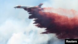A plane drops fire-retardant chemicals on the 416 Fire near Durango, Colorado, June 9, 2018.