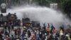 Police officers spray water using a canon to disperse demonstrators during a protest against the government's labour reforms in a polarizing jobs creation bill in Jakarta, Oct. 8, 2020.