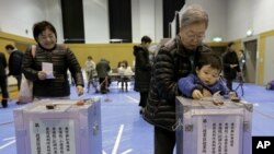 Warga Jepang memberikan suaranya dalam pemilu untuk memilih anggota parlemen di sebuah TPS di Tokyo, Minggu (16/12). Pemilu ini diperkirakan akan mengembalikan kekuasaan pemerintahan Jepang ke partai konservatif yang pernah berkuasa di Jepang selama lebih dari 50 tahun AP Photo/Itsuo Inouye).