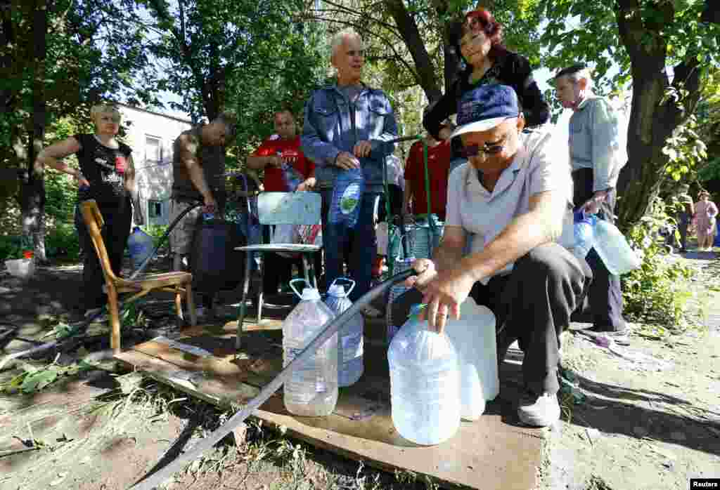 Warga setempat menimba air di Slovyansk, Ukraina Timur (1/7).
