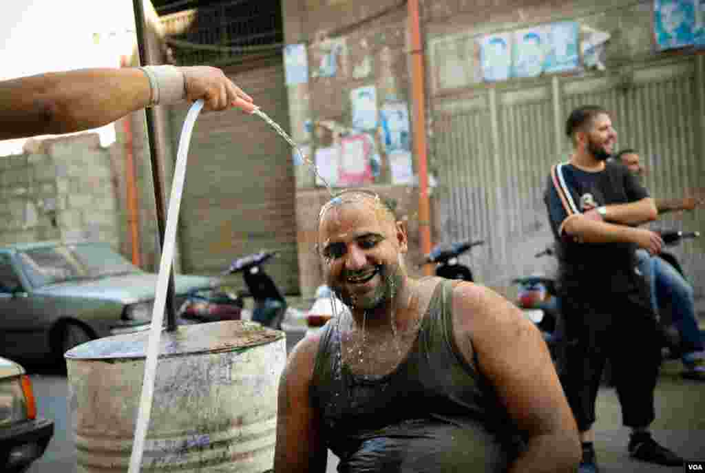 A Sunni fighter from the Bab Tabbaneh neighborhood of Tripoli, Lebanon, cools off during a lull in fighting, August 23, 2012. (VOA/Jeff Neumann)