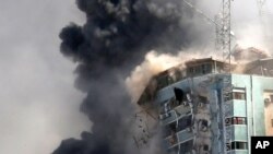 The building housing the offices of The Associated Press and other media in Gaza City collapses after it was hit by an Israeli airstrike May 15, 2021.