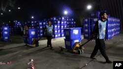 FILE: Afghan election workers transport ballot boxes for distribution ahead of presidential elections, at the Independent Election Commission compound, in Kabul, Afghanistan, Sept. 23, 2019.