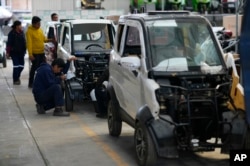 An employee works on a Quantum electric car on an assembly line at a factory in Cochabamba, Bolivia, May 9, 2023.