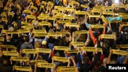 People hold banners reading "Freedom Political Prisoners" gather in support of the members of the dismissed Catalan cabinet after a Spanish judge ordered the former Catalan leaders to be remanded in custody pending an investigation into Catalonia's independence push, outside Barcelona's town hall, Nov. 3, 2017.
