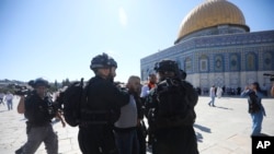 Polisi Israel menahan seorang warga Palestina di komplek masjid al-Aqsa di Yerusalem, pada perayaan hari raya Idul Adha di sana, Minggu (11/8).(AP Photo/Mahmoud Illean)
