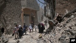 Warga sipil Irak meninggalkan tempat tinggalnya sementara Pasukan Khusus Irak terus bertempur melawan militan ISIS di Kota Tua Mosul, Irak, 29 JUni 2017. 