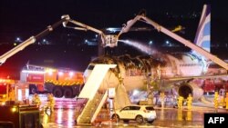 นักดับเพลิงพยายามดับไฟที่เกิดขึ้นบนเครื่องบินโดยสารของแอร์ปูซาน มุ่งหน้าสู่ฮ่องกง ที่สนามบินนานาชาติกิมแฮ ในเมืองปูซาน 28 ม.ค. 2025 (Photo by YONHAP / AFP)