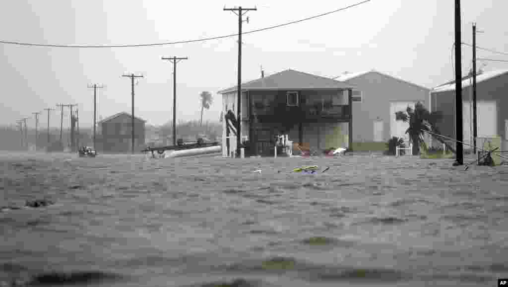 A home damaged by Hurricane Harvey remains surrounded by flood waters, Aug. 26, 2017, in Rockport, Texas.
