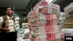 Seorang pekerja di Bank Indonesia mengatur tumpukan mata uang Rupiah (foto: dok). Nilai tukar rupiah terhadap dollar Amerika melemah minggu lalu, namun diperkirakan akan kembali menguat.