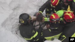 Des pompiers italiens en train d’extraire une femme vivante de sous la neige et les débris d'un hôtel frappé par une avalanche mercredi, à Rigopiano, Italie, 20 Janvier 2017.