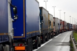 FILE - Trucks queue along the A16 motorway to board ferries to reach England, near Calais, France, Dec. 9, 2020.