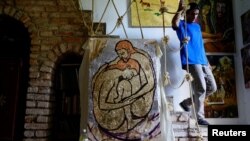 Cuban artist Italo Esposito, a participant of the "00Biennial", walks in his home next to his work in Havana, Cuba, May 2, 2018. 