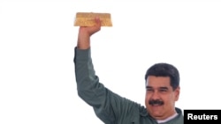FILE PHOTO: Venezuela's President Nicolas Maduro holds a gold bar during a meeting with representatives of the mining sector in Puerto Ordaz, Venezuela, Dec. 5, 2017. 