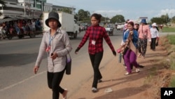 Factory workers walk as they head for home after a day's work near Kantork village outside Phnom Penh, Cambodia, Monday, June 5, 2017. (AP Photo/Heng Sinith)