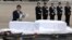 Japanese Foreign Minister Fumio Kishida, left, lays flowers on the coffins of the victims who were killed in the last weekend's attack on a restaurant in Bangladeshi capital Dhaka, at Haneda Airport in Tokyo, Tuesday, July 5, 2016.