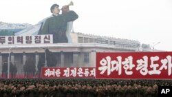 Tentara Korut memberikan sambutan yang meriah dengan bertepuk tangan dekat spanduk bertuliskan "Semangat Revolusioner", "Komandan yang Luar Biasa, Kim Jong Un" dan "Pemimpin yang Luar Biasa" dalam pawai massal di Lapangan Kim Il Sung Square di Pyongyang, Korea Utara (14/12).
