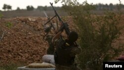Syrian Democratic Forces (SDF) fighters shoot at a drone they said belonged to Islamic State fighters on the bank of the Euphrates river, west of Raqqa, Syria, April 8, 2017. 