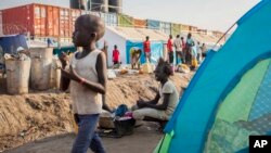 FILE - A young displaced girl washes clothes alongside a row of tents in the United Nations camp in Juba, South Sudan, Feb. 12, 2014.